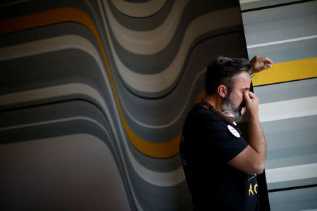 Manuel Oliver, father of Joaquin Oliver one of the victims of the mass shooting at Marjory Stoneman Douglas High School, cries in his hotel room before painting a mural to commemorate the victims of the shooting and promote gun control in Los Angeles, California, U.S., April 7, 2018. REUTERS/Carlos Garcia Rawlins