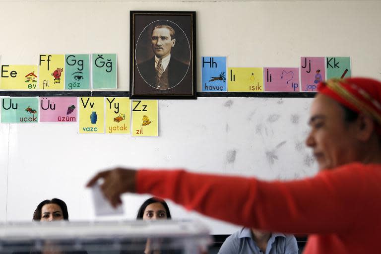 A Turkish Cypriot woman casts her vote at a polling station in the eastern port city of Famagusta in front of a portrait of Mustafa Kemal Ataturk, the founder of modern Turkey, during the second round of the presidential elections on April 26, 2015