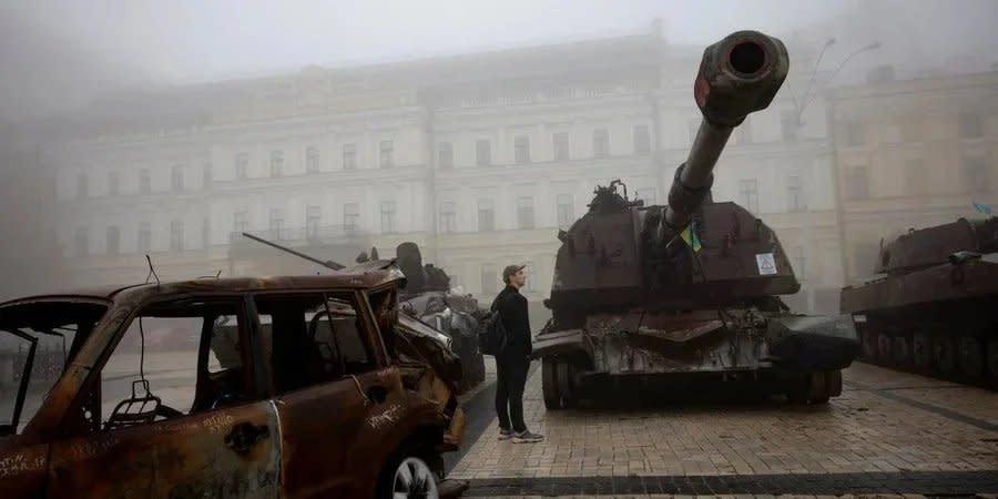 A man near destroyed Russian equipment in Kyiv