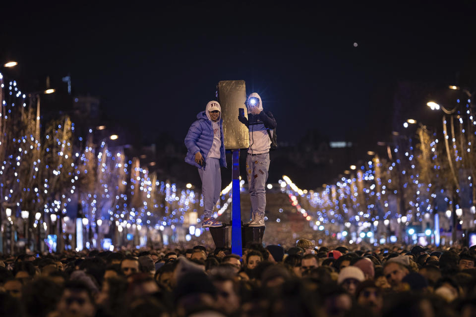 Una multitud observa un espectáculos de luz y sonido proyectado sobre el Arco del Triunfo por motivo del Año Nuevo en París, Francia, el sábado 31 de diciembre de 2022. (AP Foto/Aurelien Morissard)