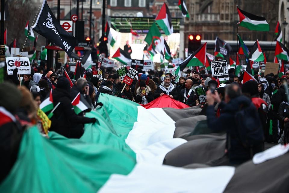 Pro-Palestinian activists and supporters display a large Palestinian flag during a national march for Palestine in central London (AFP via Getty)
