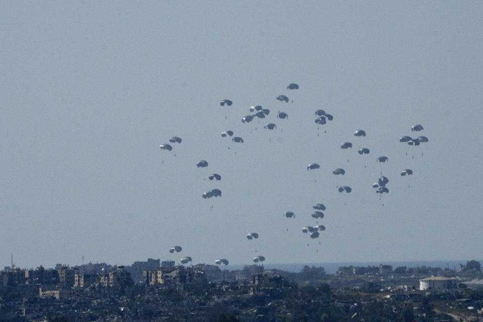 Paracaídas con ayuda humanitaria caen sobre el norte de la Franja de Gaza, vistos desde el sur de Israel, el 11 de marzo de 2024. (AP Foto/Maya Alleruzzo)