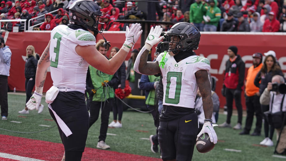 Oregon's running back Bucky Irving (0) celebrates his touchdown with teammate Terrance Ferguson (3) during the second half of an NCAA college football game against Utah Saturday, Oct. 28, 2023, in Salt Lake City. (AP Photo/Rick Bowmer)