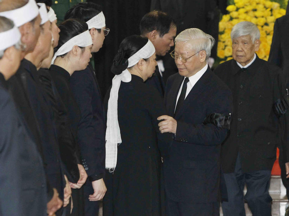 Communist Party General Secretary Nguyen Phu Trong, center, talks to Nguyen Thi Hien, widow of late Vietnamese President Tran Dai Quang in Hanoi, Vietnam, Wednesday, Sept. 26, 2018. Hundreds of mourners are paying tribute to the president who died of viral illness last week. (Bui Doan Tan/Vietnam News Agency via AP)