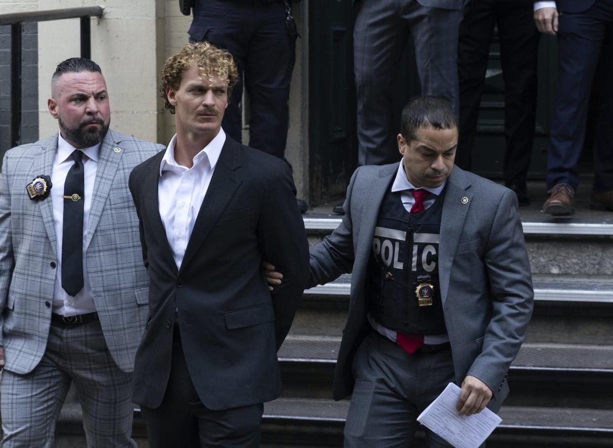 Daniel Penny, centre, is walked by New York Police Department detectives out of a Manhattan precinct in May 2023. He was charged with manslaughter in the death of Jordan Neely. (AP Photo/Jeenah Moon)