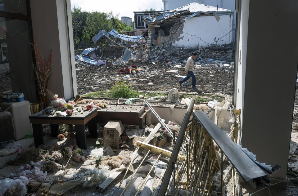 A man walks past a house destroyed by shelling by Azerbaijan's artillery during a military conflict in Stepanakert, self-proclaimed Republic of Nagorno-Karabakh, Thursday, Oct. 8, 2020. Armenia accused Azerbaijan of firing missiles into the capital of the separatist territory of Nagorno-Karabakh, while Azerbaijan said several of its towns and its second-largest city were attacked. (AP Photo)