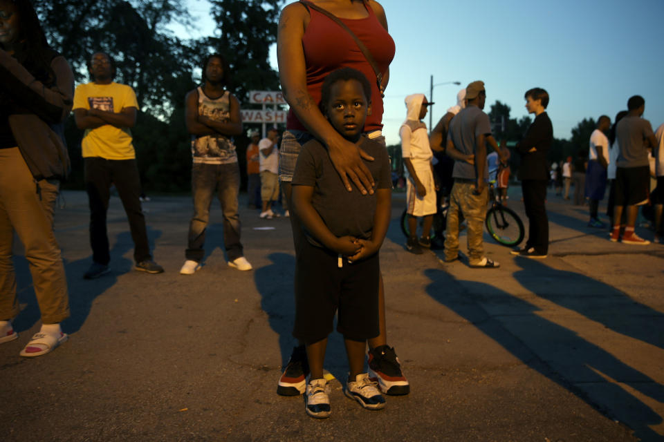 <p>Jeremiah Parker, 4, stands in front of his mother, Shatara Parker, as they attend a protest Wednesday, Aug. 13, 2014, in Ferguson, Mo. Nights of unrest have vied with calls for calm in a St. Louis suburb where Michael Brown, an unarmed black teenager was killed by police, while the community is still pressing for answers about the weekend shooting. (AP Photo/Jeff Roberson) </p>