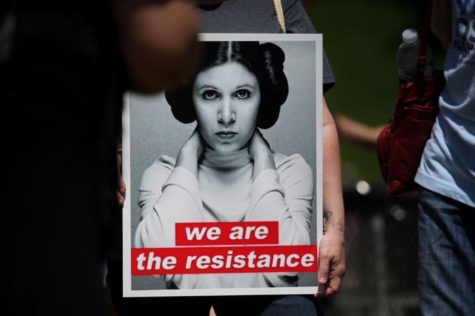 A protester holds a sign featuring ‘Star Wars’ character Princess Leia made in the style of Kruger’s iconic ‘Battleground’ poster. <a href="https://www.gettyimages.com/detail/news-photo/portrait-of-carrie-fisher-as-princess-leia-is-displayed-news-photo/1240707306?adppopup=true" rel="nofollow noopener" target="_blank" data-ylk="slk:Erin Clark/The Boston Globe via Getty Images;elm:context_link;itc:0;sec:content-canvas" class="link ">Erin Clark/The Boston Globe via Getty Images</a>