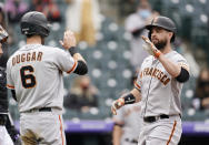 San Francisco Giants' Steven Duggar, left, waits to congratulate Brandon Belt as he crosses home plate after hitting a three-run home run in the first inning of game one of a baseball doubleheader Tuesday, May 4, 2021, in Denver. (AP Photo/David Zalubowski)