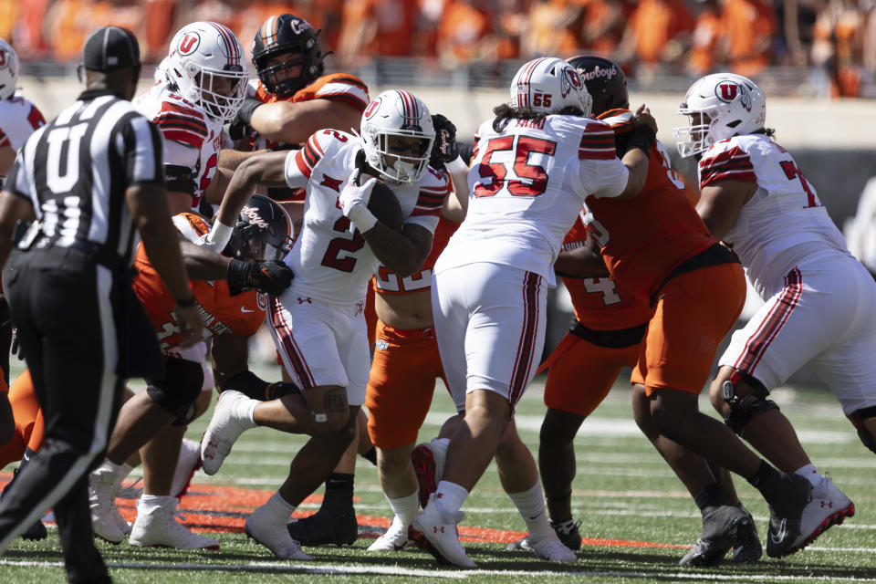 Utah running back Micah Bernard (2) runs past Oklahoma States defensive end Obi Ezeigbo (33) during the first half of an NCAA college football game, Saturday, Sept. 21, 2024, in Stillwater, Okla. (AP Photo/Mitch Alcala)