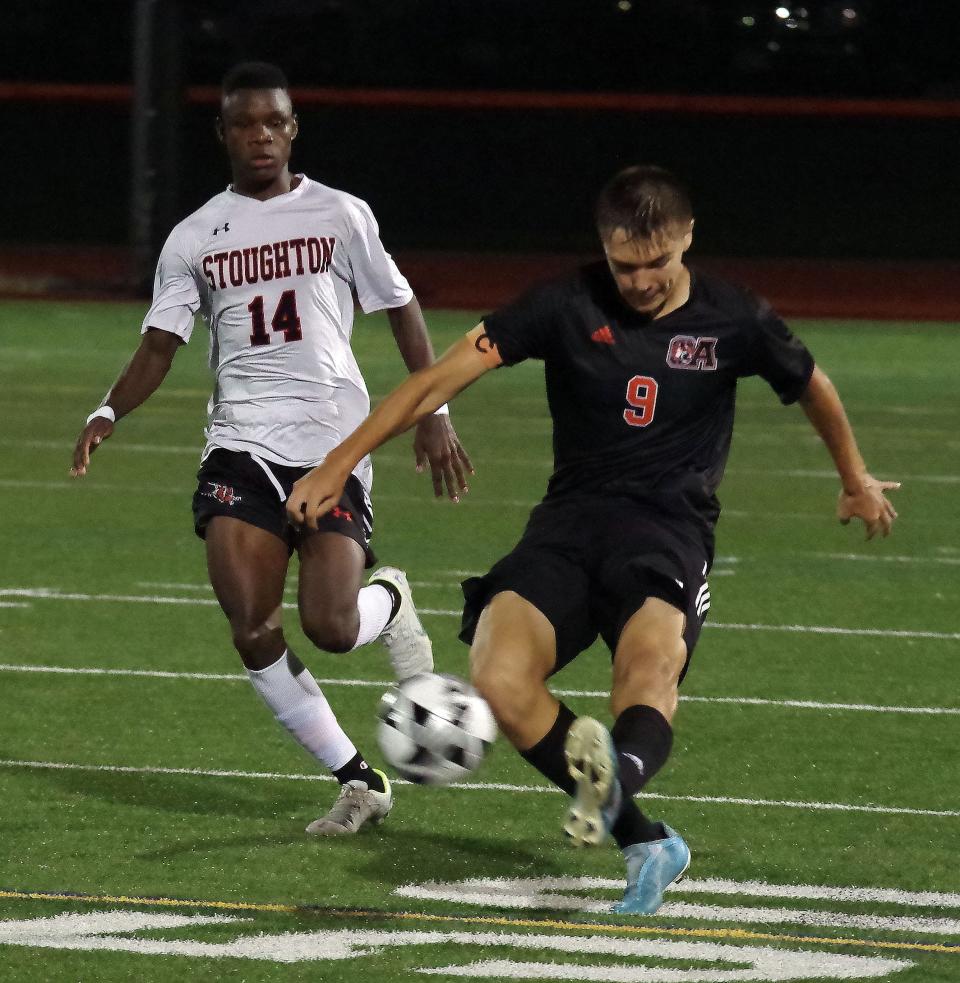 Oliver Ames' Hector Bucio senior and co-captain, clears the ball into the Stoughton end with Stoughton's Samuel Santos hot on his heels during the soccer match in Easton on Monday, Sept. 12, 2022.