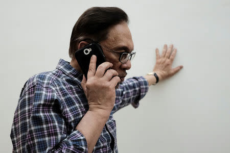 Malaysian politician Anwar Ibrahim takes a phone call during during an interview with Reuters at his house in Kuala Lumpur, Malaysia May 17, 2018. REUTERS/Stringer