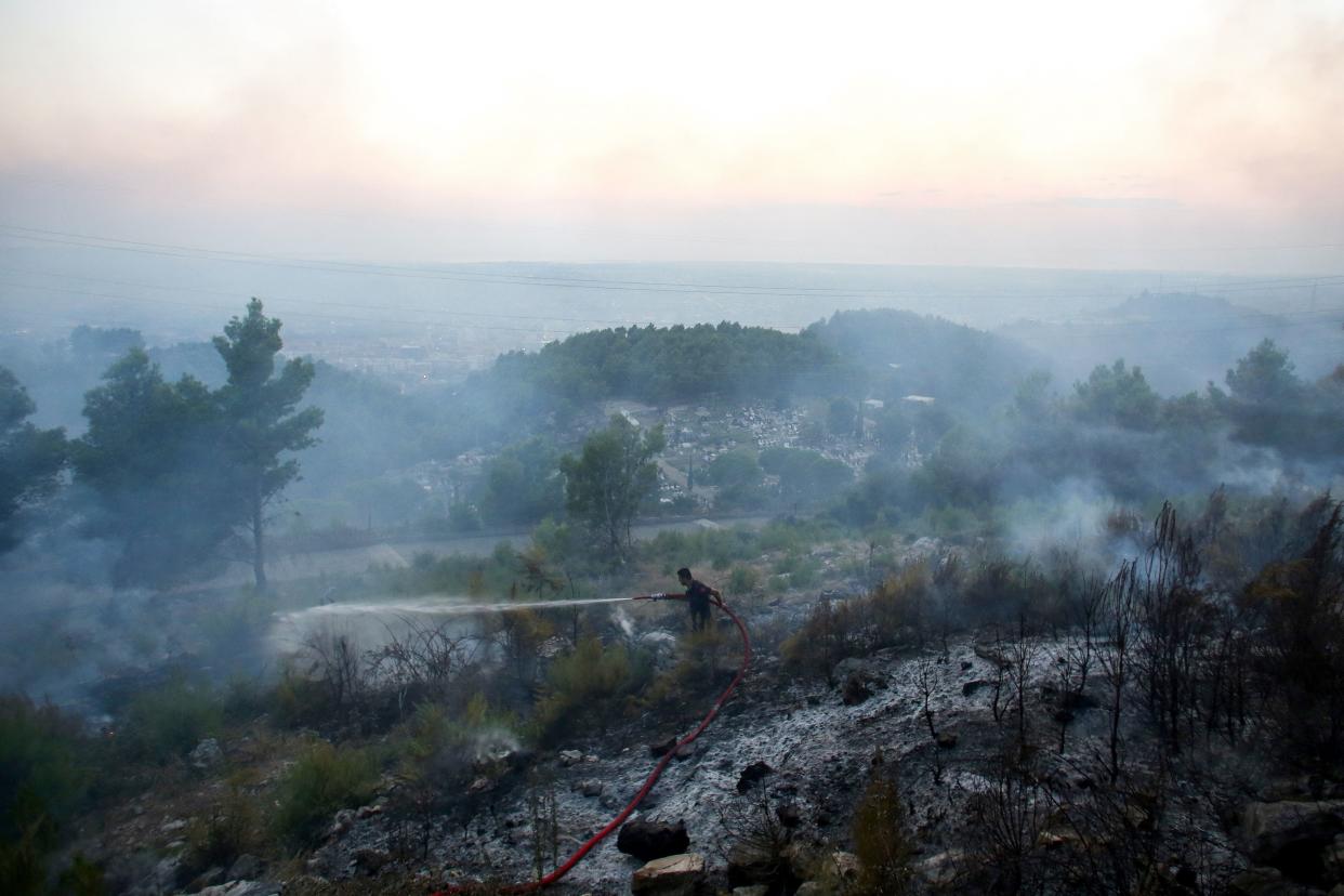 Firefighters battle a wildfire just north of Tirana in summer 2024. (Getty)