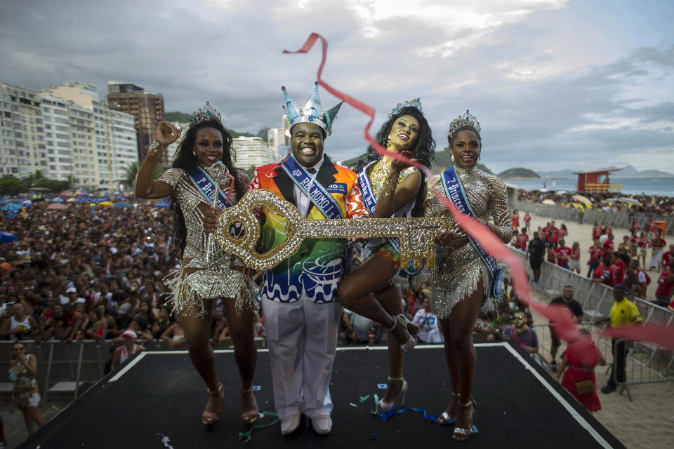 Carnival King Momo, Djeferson Mendes da Silva, second from left, holds the key to the city at a ceremony marking the official start of Carnival on Copacabana beach, Rio de Janeiro, Brazil, Sunday, Jan. 12, 2020. (AP Photo/Bruna Prado)