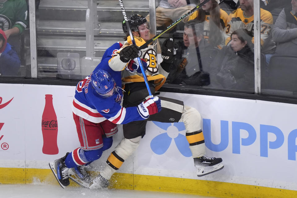 New York Rangers defenseman Zac Jones (6) and Boston Bruins forward Jesper Boqvist (70) slam into the boards in the second period of an NHL hockey game, Thursday, March 21, 2024, in Boston. (AP Photo/Steven Senne)