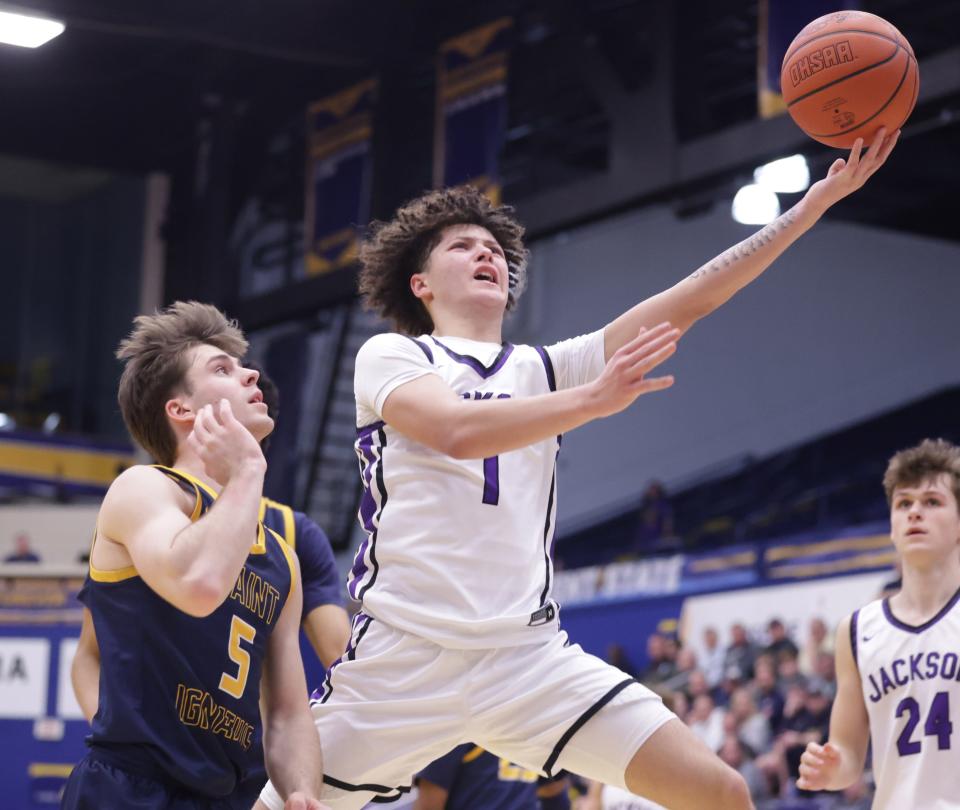 Jackson's Cameron Weekley drives against Cleveland St. Ignatius' Matt Ellis in an OHSAA boys basketball regional semifinal at Kent State, Wednesday, March 13, 2024.