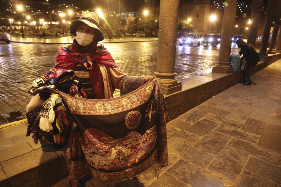 Herminia Mena sells Sndean cloth in an empty Plaza de Armas amid the COVID-19 pandemic in downtown Cusco, Peru, Friday, Oct. 30, 2020. (AP Photo/Martin Mejia)