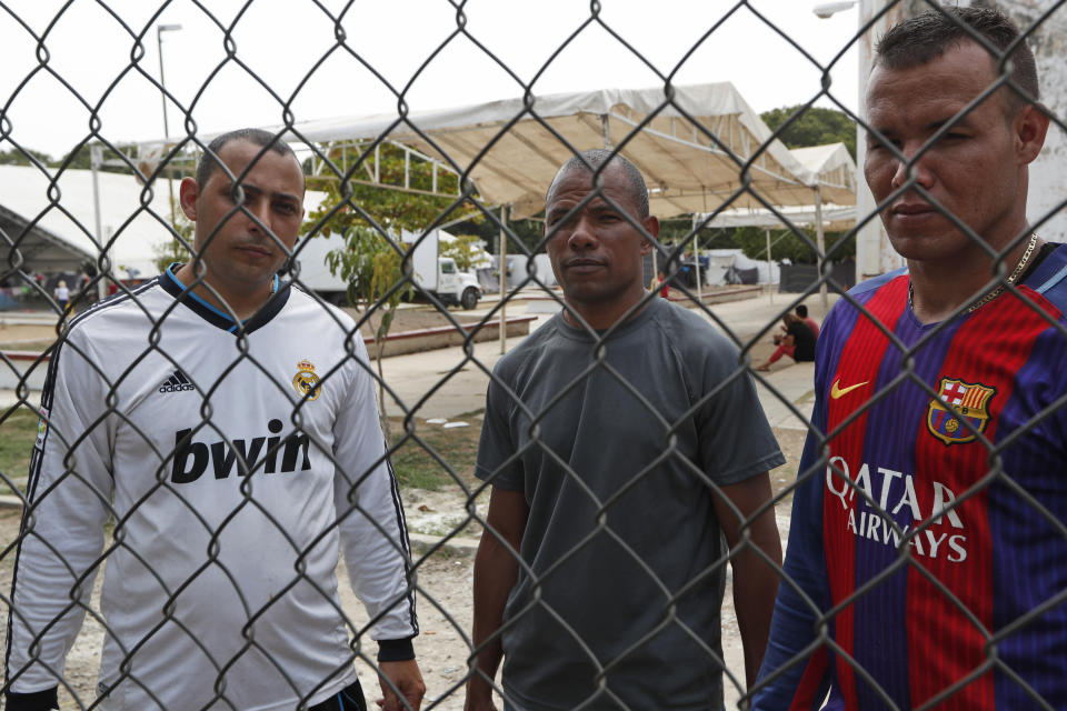 In this April 25, 2019 photo, Cuban migrants Jorge Luis Hernandez, left, Johan Diaz, center and Mike Garcia pose for photos inside a shelter set up in Mapastepec, Chiapas state. This group of migrants are waiting for humanitarian visas. They traveled from Cuba to Uruguay and from there by road to the state of Chiapas on the border between Mexico and Guatemala. (AP Photo/Moises Castillo)