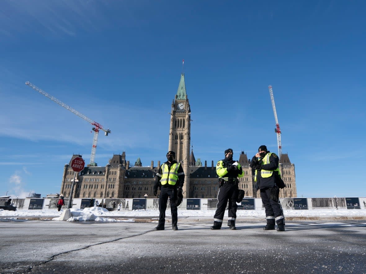 A few police officers stand on Parliament Hill as the number of protesters began to swell on Jan. 28. (Ivanoh Demers/CBC - image credit)