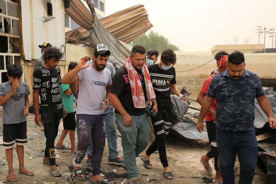 Rescuers and civilians look for bodies after a catastrophic blaze erupted Monday at a coronavirus hospital ward in the al-Hussein Teaching Hospital, in Nasiriyah, Iraq, Tuesday, July 13, 2021. Iraqi medical officials said the death toll from the fire in Nasiriyah had risen to over 60. Two health officials said on Tuesday that more than 100 people were also injured. (AP Photo/Khalid Mohammed)