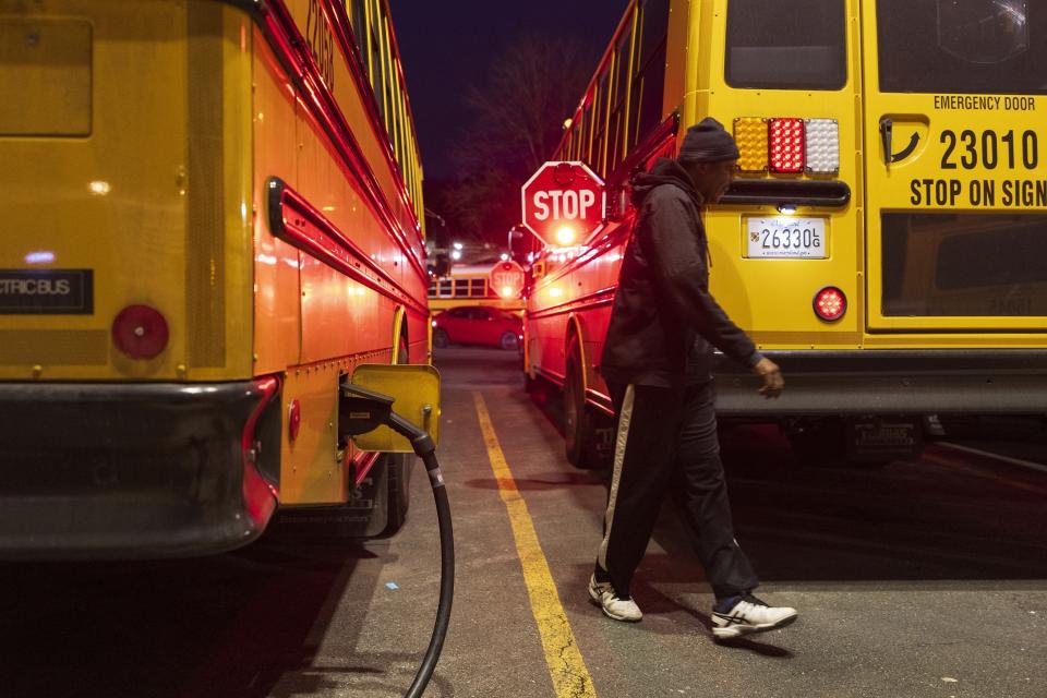 A electric school bus driver examines his safety stop signs before driving to school inside the Montgomery County Schools bus lot, Friday, Feb. 9, 2024, in Rockville, Md. (AP Photo/Tom Brenner)