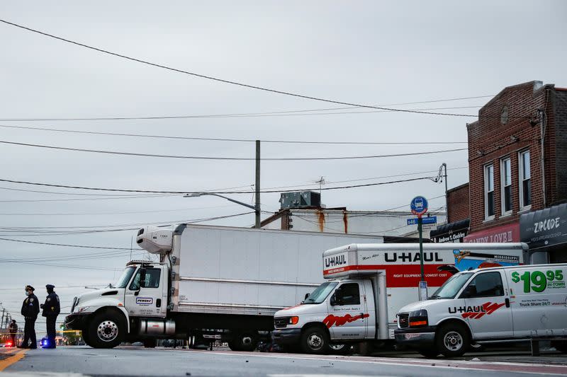 officers secure trucks full of bodies of deceased people, during the outbreak of coronavirus disease (COVID-19) at the Andrew Cleckley Funeral Home in Brooklyn, New York