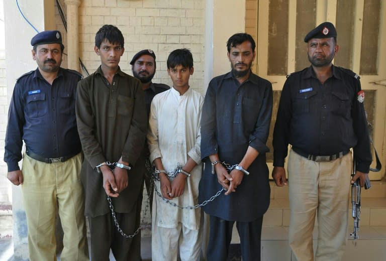 Pakistani policemen escort Tariq Mehmood (2nd right), his younger brother Khalid Mehmood (2nd left) and an employee (centre) at a court in Pakistan's Punjab province