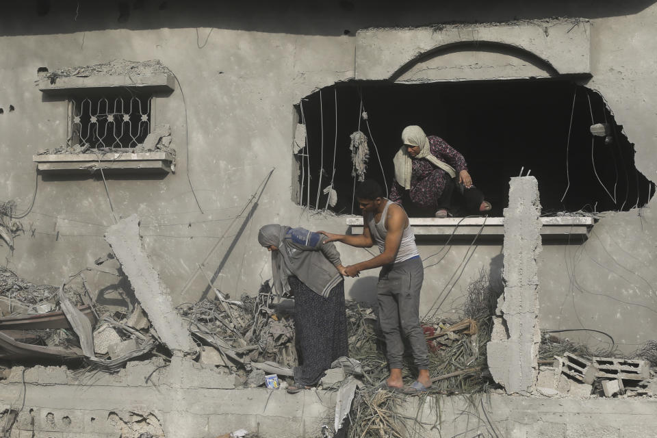 Palestinians evacuate a building damaged in the Israeli bombardment of the Gaza Strip in Rafah on Sunday, Oct. 22, 2023. (AP Photo/Hatem Ali)