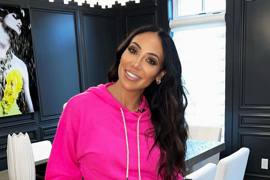 Melissa Gorga smiling in a hot pink hoodie.