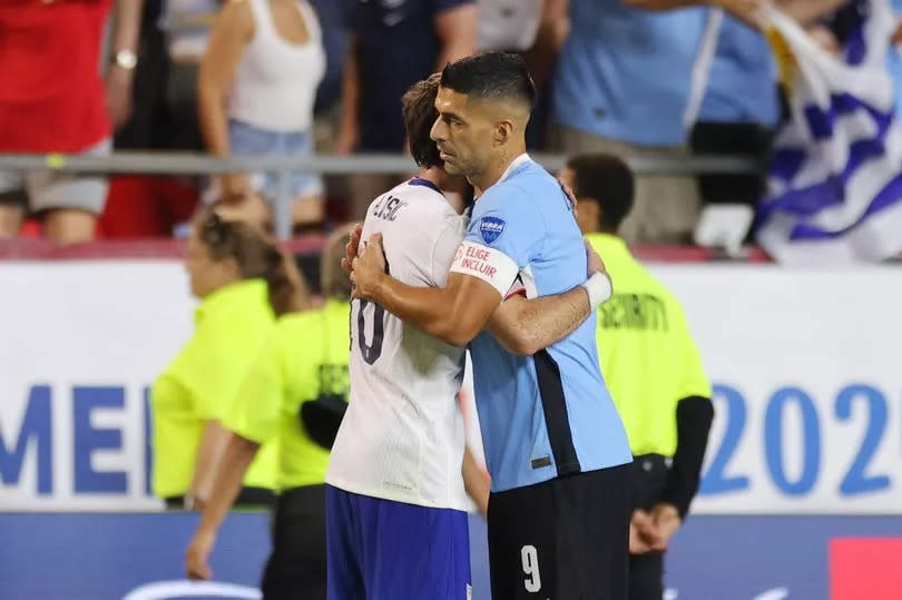 Christian Pulisic #10 of the United States hugs Luis Suarez #9 of Uruguay after the game at GEHA Field at Arrowhead Stadium on July 01, 2024 in Kansas City, Missouri.