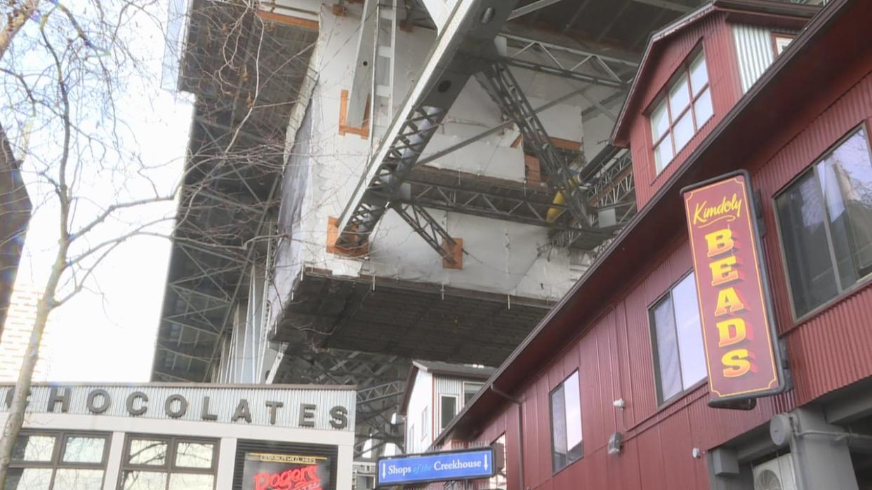 The manager of Creekhouse on Granville Island in Vancouver says debris falling from the Granville Street Bridge due to deterioration, construction and vandalism poses significant safety risks and is costing businesses. (CBC News - image credit)