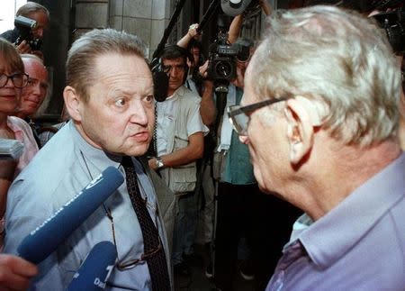 Guenther Schabowski (L), a former member of East Germany's communist leadership, argues with a man who called him a traitor as he enters a courtroom in Berlin, August 25. Reuters Photographer