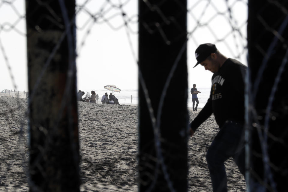 People pass along the beach in Tijuana, Mexico, seen through the border wall before a visit by Homeland Security Secretary Kirstjen Nielsen, Tuesday, Nov. 20, 2018, in San Diego. Nielsen said Tuesday an appeal will be filed on the decision by a judge to bar the Trump administration from refusing asylum to migrants who cross the southern border illegally. (AP Photo/Gregory Bull)