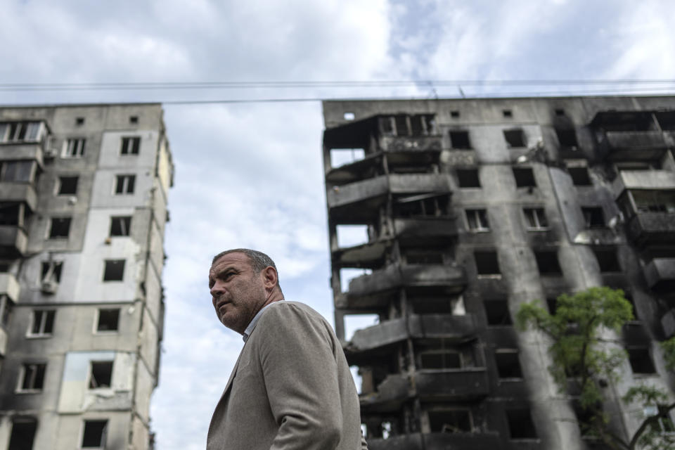 American actor Liev Schreiber stands in front of a house which have been destroyed by Russia bombardment in Borodianka, near Kyiv, Ukraine, on Monday, Aug. 15, 2022. (AP Photo/Evgeniy Maloletka)