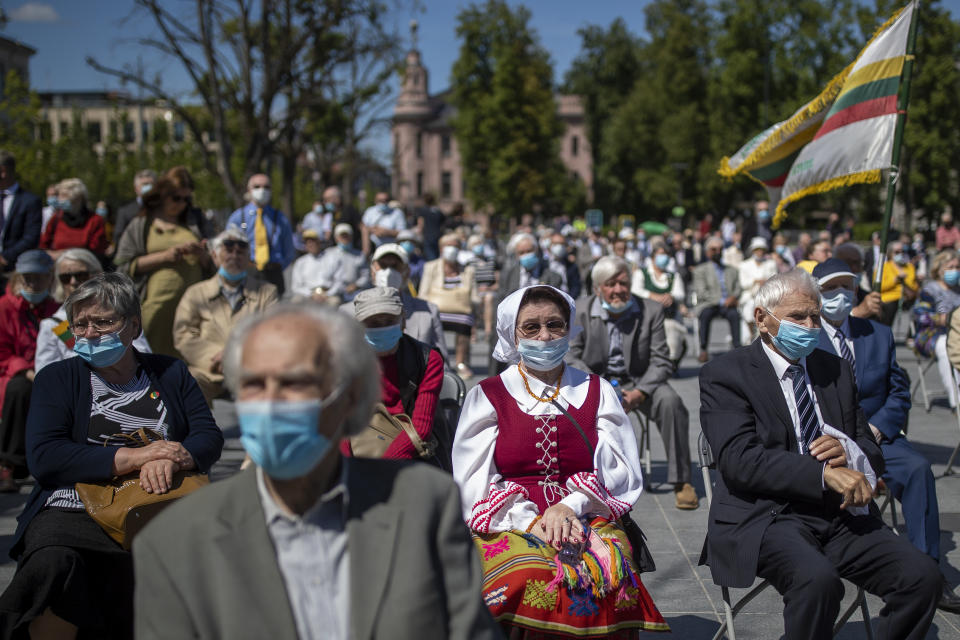 Lithuanian people attend a commemoration in Vilnius, Lithuania, Monday, June 14, 2021, marking the mass deportation 80 years ago by the Soviet Union that was occupying the Baltic nation. Deportation started on June 14, 1941, where some 280,000 people were deported to Siberian gulags, a year after Soviet troops had occupied Lithuania. (AP Photo/Mindaugas Kulbis)