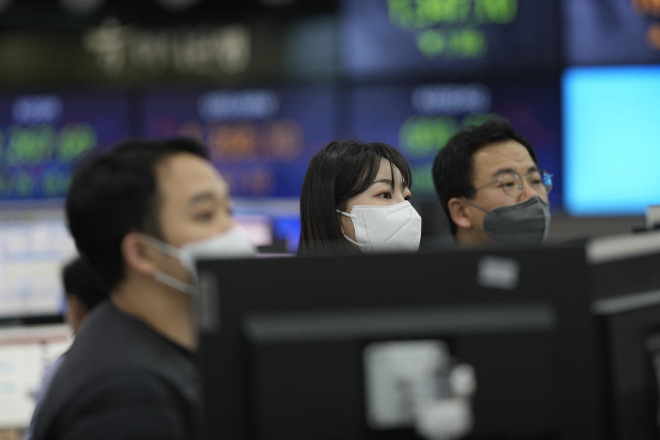 Currency traders stand near the screens showing the foreign exchange rates at a foreign exchange dealing room in Seoul, South Korea, Thursday, Dec. 29, 2022. Shares slipped in Asia on Thursday after benchmarks fell more than 1% on Wall Street in the middle of a mostly quiet and holiday-shortened week. (AP Photo/Lee Jin-man)