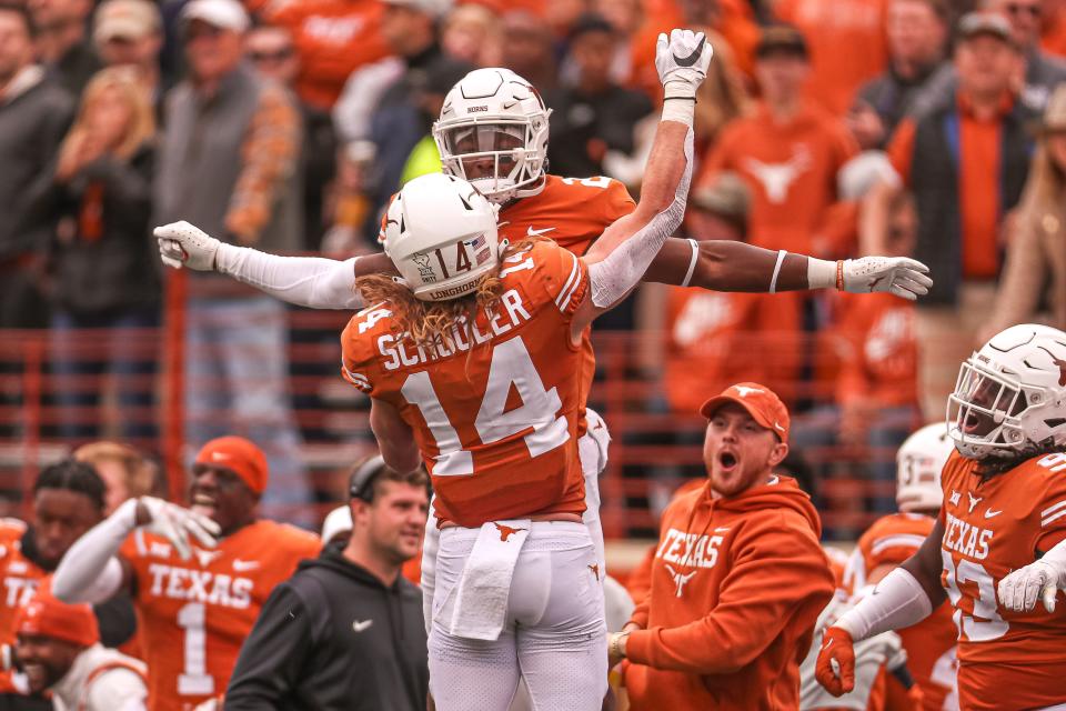 Texas defensive back Brenden Schooler (14) and wide reciever Tryo Omeire (21) celebrate a defensive stop during the Texas game against Kansas State at Royal Memorial Stadium in Austin, Texas on Nov. 26, 2021. Texas defeated Kansas State 22-17.