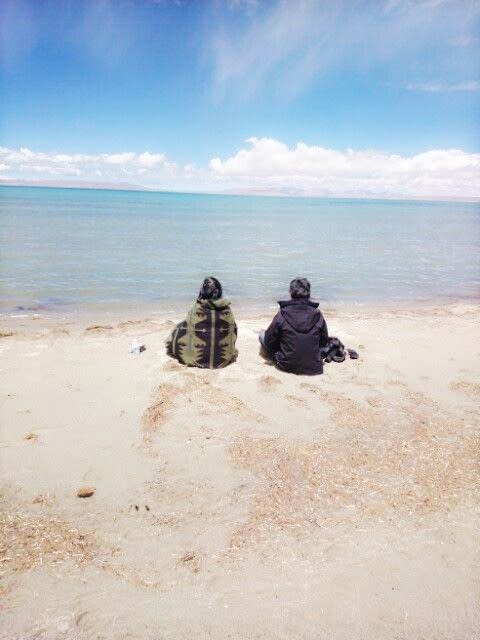 夫妻倆面對著聖湖，靜靜地享受這份水天一色的美景。