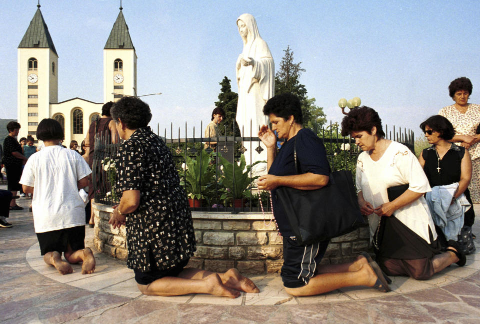 Bosnian Roman Catholic women pray on the occasion of the feast of the Assumption in Medjugorje, some 120 kilometers (75 miles) south of the Bosnian capital Sarajevo on Tuesday, August 15, 2000. Some 19 years ago six young people claimed Holy Mary appeared to them in the town of Medjugorje. On Friday, May 17, 2024, the Vatican will issue revised norms for discerning apparitions "and other supernatural phenomena," updating a set of guidelines first issued in 1978. (AP Photo/Hidajet Delic, File)