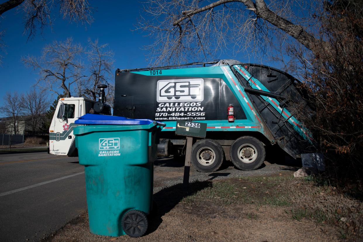 A Gallegos Sanitation vehicle services a home off West Prospect Street in Fort Collins, Colorado on Wednesday, March 23, 2022.