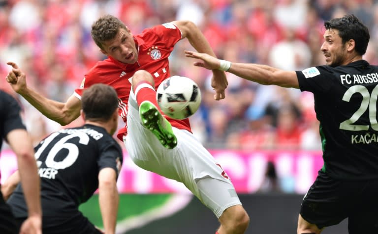 Bayern Munich's Thomas Mueller (C) controls the ball under pressure from Augsburg players in Munich, southern Germany, on April 1, 2017