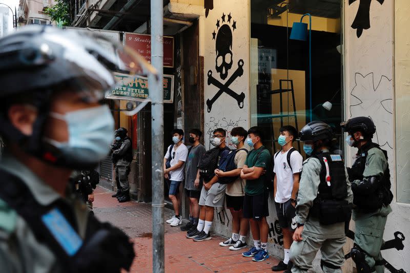 Riot police stop and search people during a march against national security law at the anniversary of Hong Kong's handover to China from Britain in Hong Kong