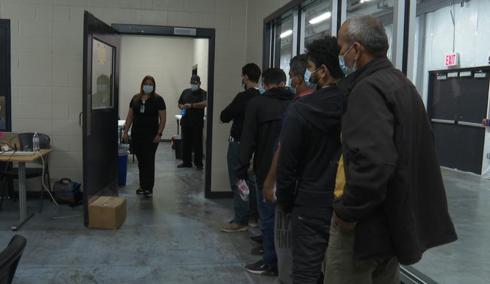 Migrants prepare to receive their COVID-19 shots at a border facility in McAllen, Texas, on Tuesday, May 17, 2022. / Credit: Nicole Sganga / CBS News