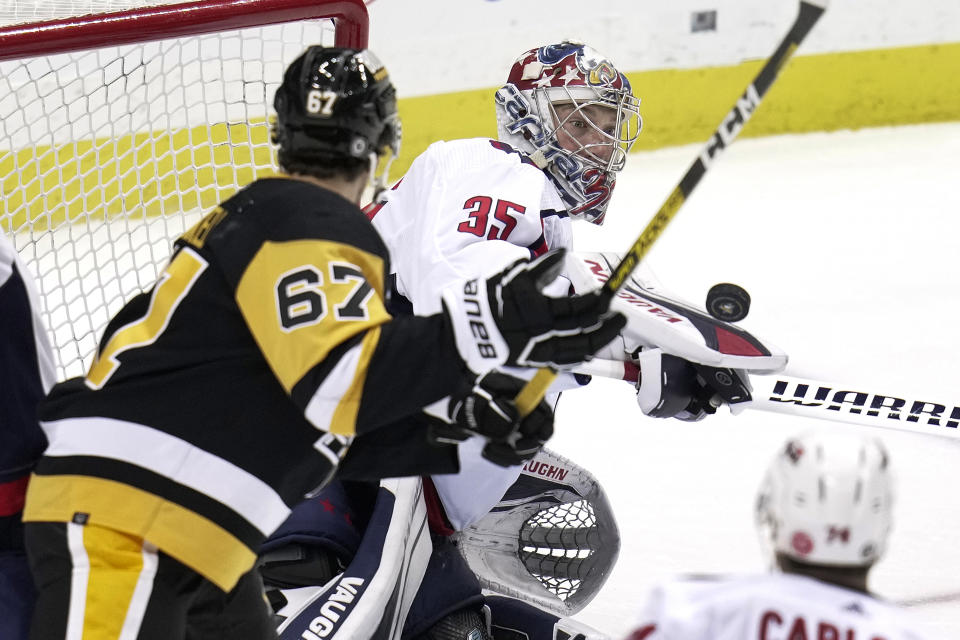 Washington Capitals goaltender Darcy Kuemper (35) blocks a shot in front of Pittsburgh Penguins' Rickard Rakell (67) during the first period of an NHL hockey game in Pittsburgh, Saturday, March 25, 2023. (AP Photo/Gene J. Puskar)