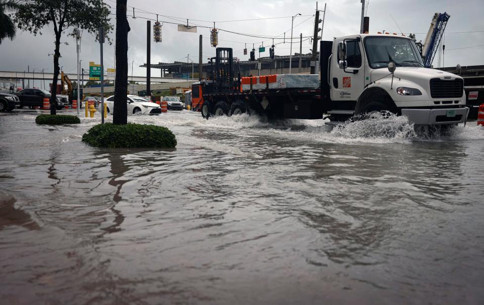 Exit 2 off of the MacArthur Causeway floods over the road and onto the sidewalk during a rain storm, Wednesday, April 12, 2023, in Miami. A torrential storm bought heavy showers, gusty winds, and thunderstorms to South Florida on Wednesday and prompted the closure of Fort Lauderdale-Hollywood International Airport and the suspension of high-speed commuter rail service in the region.