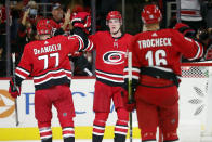 Carolina Hurricanes' Andrei Svechnikov, center, is congratulated on his empty-net goal by teammates Tony DeAngelo (77) and Vincent Trocheck during the third period of an NHL hockey game against the New York Islanders in Raleigh, N.C., Thursday, Oct. 14, 2021. (AP Photo/Karl B DeBlaker)