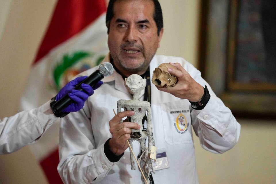 Forensic archaeologist Flavio Estrada from Peru's prosecutor's office shows a doll, which was seized by authorities before it was shipped to Mexico, during a press conference to explain what it is made of at the Archeology Museum in Lima, Peru, Friday, Jan. 12, 2024.