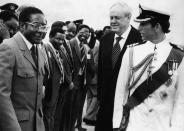 <p>Britain’s Prince Charles shares a word with Zimbabwean Prime Minister Robert Mugabe, while British Governor Christopher Soames and the Rhodesian cabinet look on, in Salisbury (now Harare), Rhodesia (now Zimbabwe), on April 16, 1980. (Photo: AP) </p>