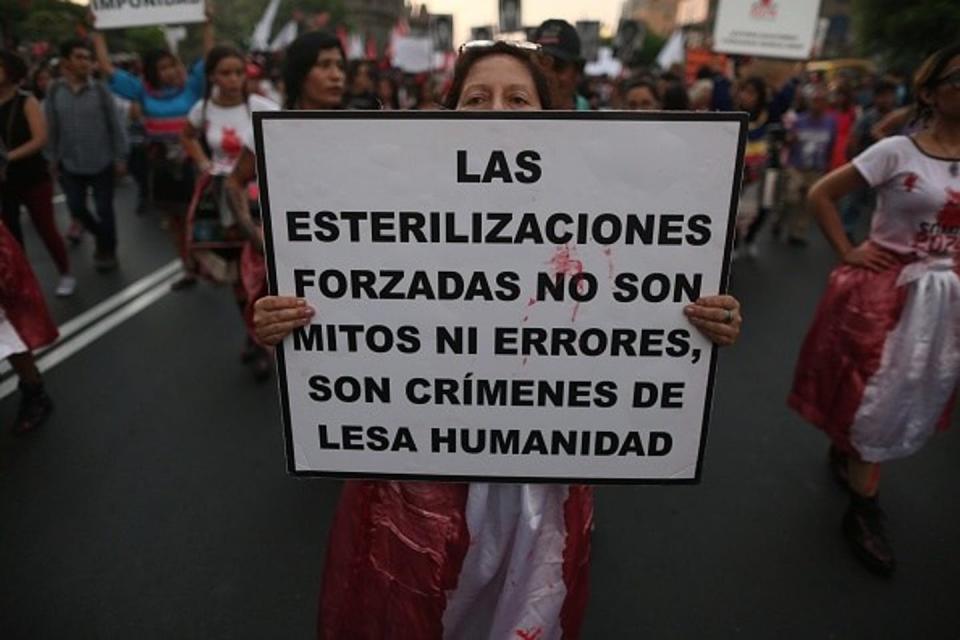 Peruvian protester holds a sign reading, 'Forced sterilizations are not myths or errors; they are crimes against humanity.'