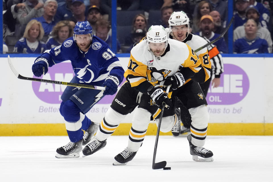 Pittsburgh Penguins right wing Bryan Rust (17) breaks out ahead of teammate center Sidney Crosby (87) and Tampa Bay Lightning center Steven Stamkos (91) during the first period of an NHL hockey game Thursday, Nov. 30, 2023, in Tampa, Fla. (AP Photo/Chris O'Meara)